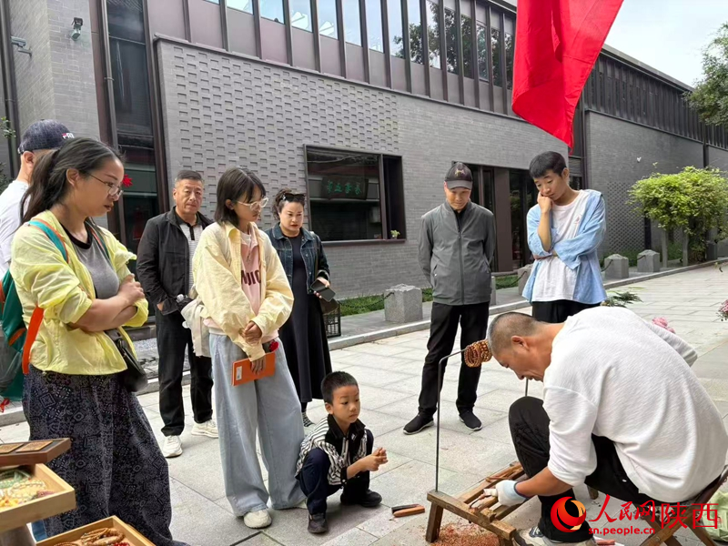 游客正在观看王小彬手工雕刻过程。人民网 王丽摄
