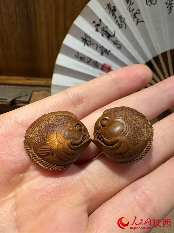 用果核雕刻的“小鱼”。人民网 王丽摄