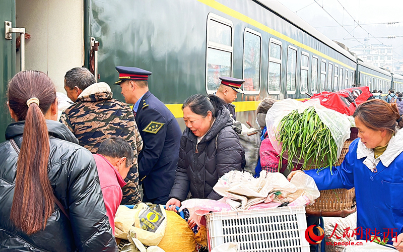 向寶林幫老鄉把貨物抬上車。李弢攝