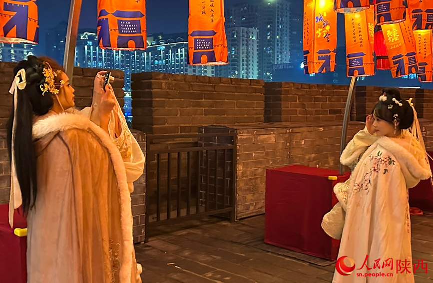 游客穿汉服在花灯下拍照留念。人民网记者 白鸽摄