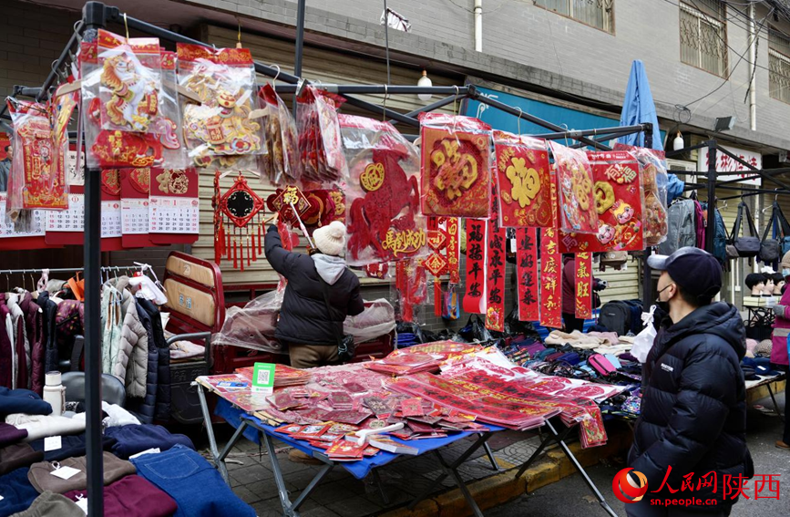 早上8点，在西仓市集，售卖春联、福字等年货的摊主正在整理货品。人民网记者 邹星摄