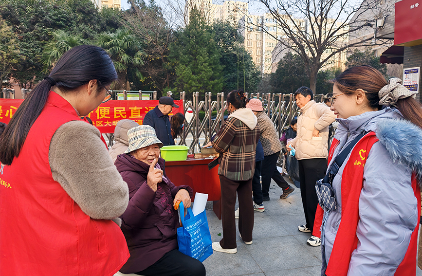 吳晗（右一）在未央區鼎新社區便民服務日，為老年人答疑解惑。受訪者供圖