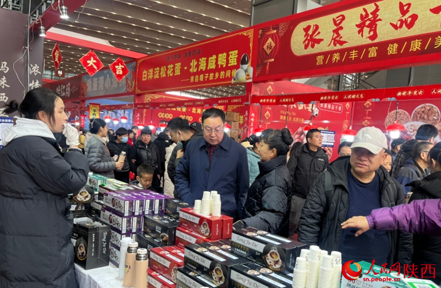 第21屆西安年貨會現場,市民選購年貨商品。人民網記者 魏鑫攝