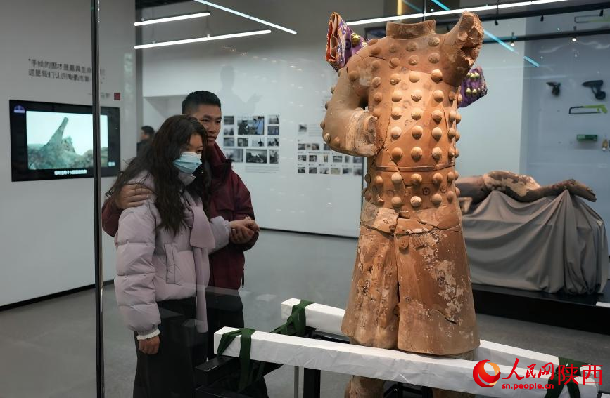 观众参观4号百戏俑及其复原服饰。