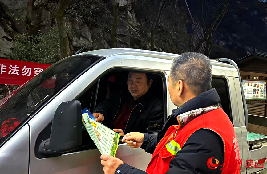 夜幕下,董新建在检查点为过往车辆登记并讲解相关政策。人民网记者 孙挺摄