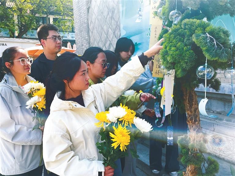 4月1日,西安市碑林区南院门街道德福巷社区举办公祭活动。图为群众以寄语寄哀思、以风铃传思念。