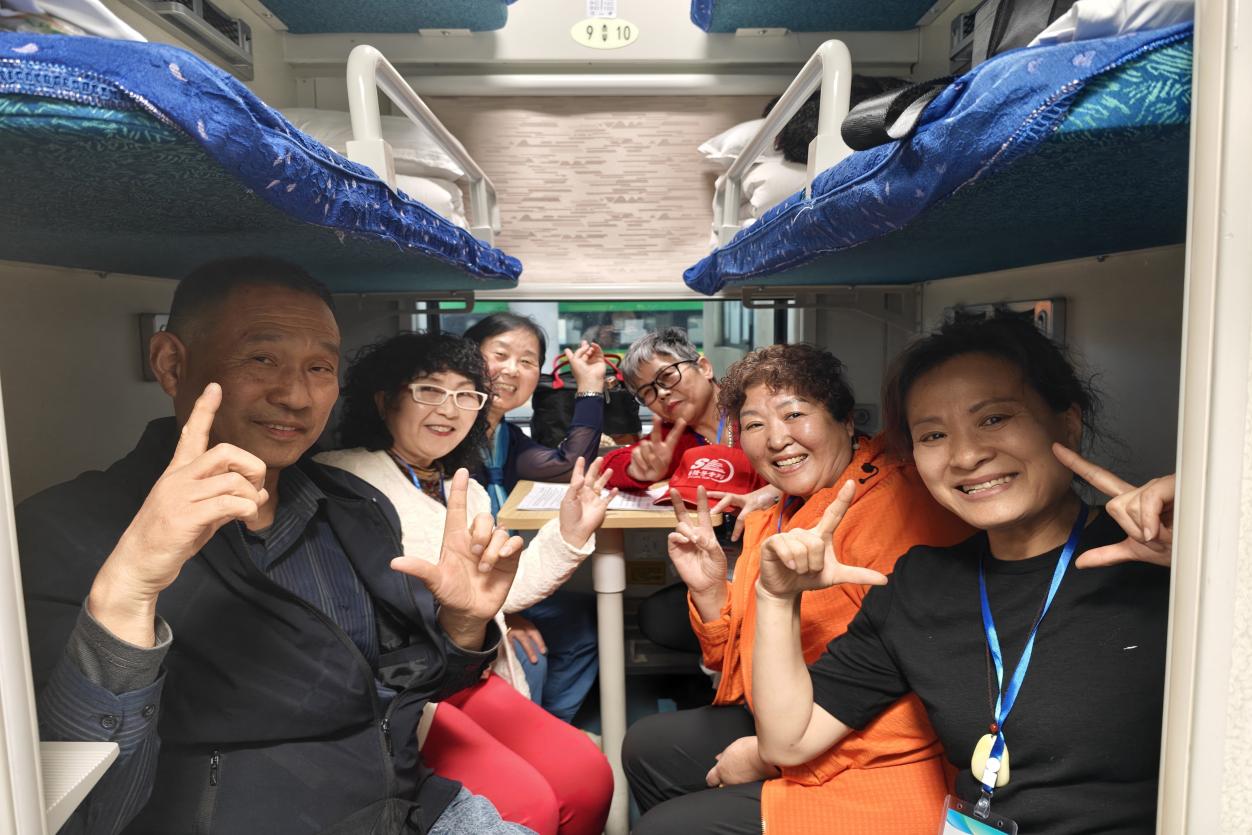 旅客在列车上合影留念。薛心如摄