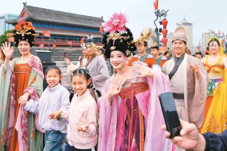 “五一”假期，西安城墙景区推出“长安巡·步步盛唐”大型唐风巡演盛典。图为小游客和演员们一起巡演。李明摄