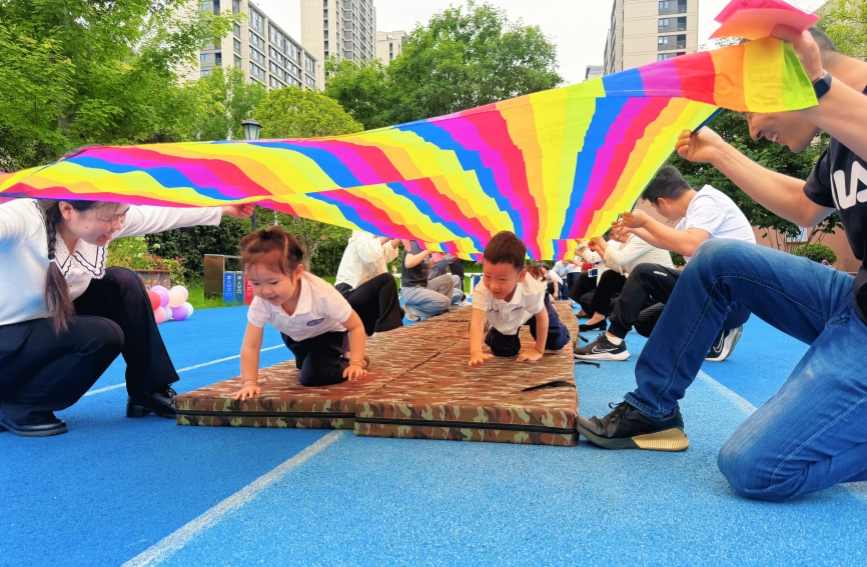 5月29日，西安国际港务区陆港第六幼儿园，孩子们在做亲子游戏。西安国际港务区供图
