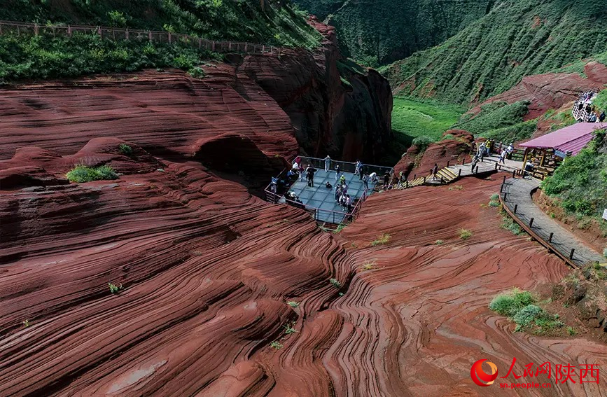 雨后丹霞岩层色泽鲜亮,游客驻足观景台打卡美景。人民网记者 孙挺摄