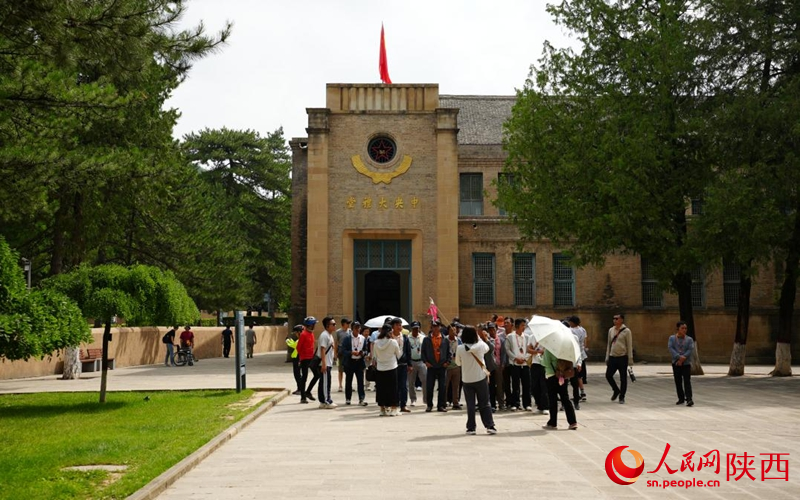 游客在杨家岭革命旧址的中央大礼堂前打卡留念。人民网记者 李志强摄