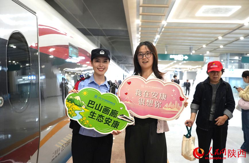 旅客与列车工作人员合影留念。人民网记者 贾凯璐摄