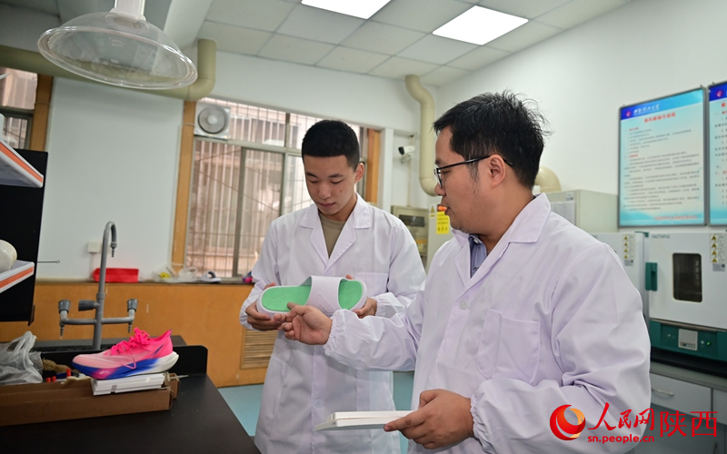 李峰教授（右）对企业提出的技术问题开展研究。人民网记者 李志强摄