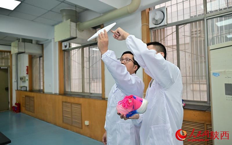李峰教授（左）指导研究生研制下一代高弹性智能鞋材。人民网记者 李志强摄