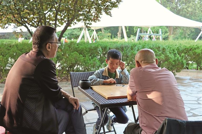 9月21日,在西安市碑林区长乐公园城市书屋门口,围棋爱好者在切磋交流(资料照片)。