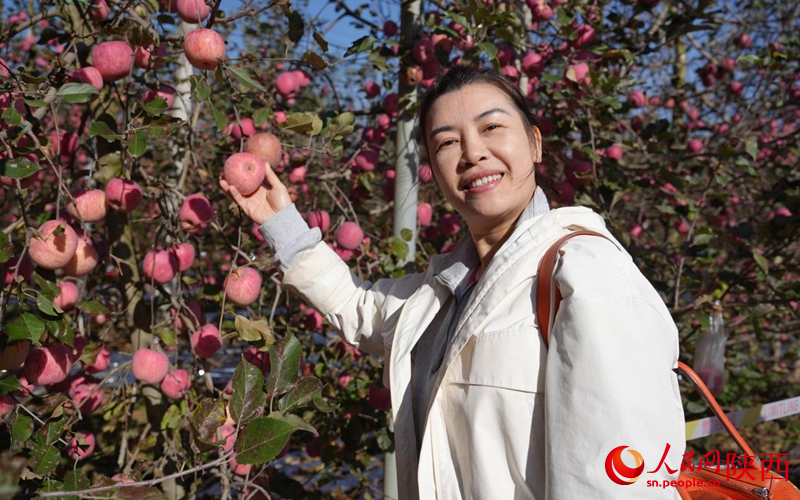 越南的采购商与苹果合影。人民网记者 贾凯璐摄