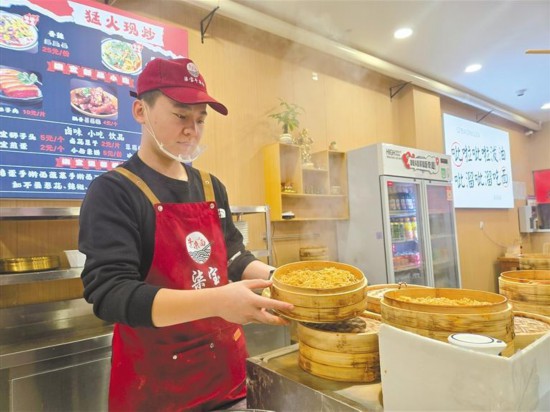 12月5日，在柒宝牛杂面面馆，王高民在制作面食。