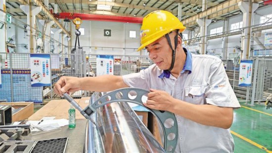 7月8日，在陕西北人印刷机械有限责任公司生产车间的综合检验区，工人检验零件精度。记者 霍海澎摄