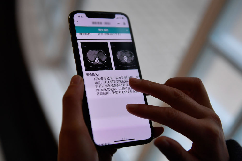 2021年1月20日，在杭州市余杭區第一人民醫院，居民通過手機使用“健康余杭智慧雲共享平台”查看檢查圖文報告。新華社記者 黃宗治 攝